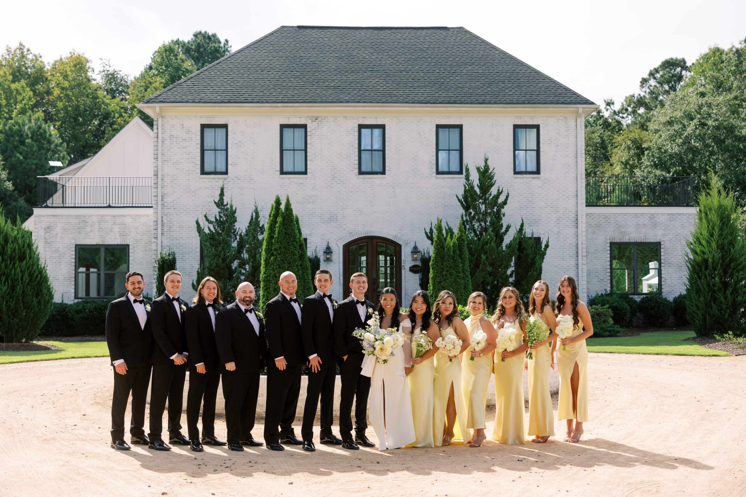 Bride and groom with wedding party The Bradford North Carolina Wedding Venue, showcasing elegant wedding attire and timeless love.