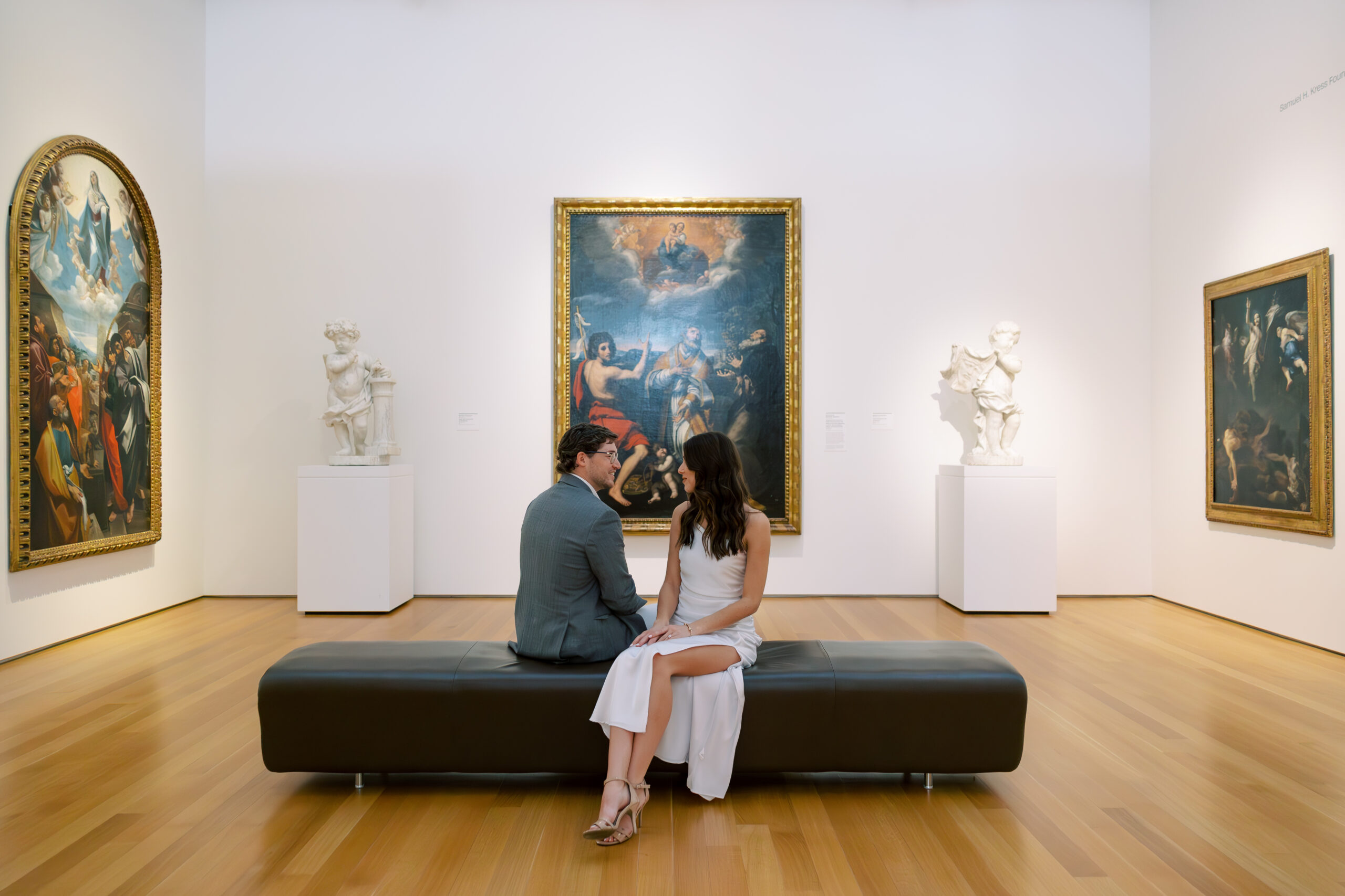 A couple standing in front of a modern sculpture at the NC Museum of Art during their Raleigh engagement session.